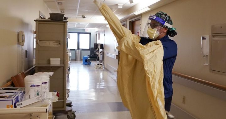 Registered Nurse Monica Quintana dons protective gear before entering a room at the William Beaumont hospital on April 21, 2021 in Royal Oak, Mich. (Carlos Osorio/AP)