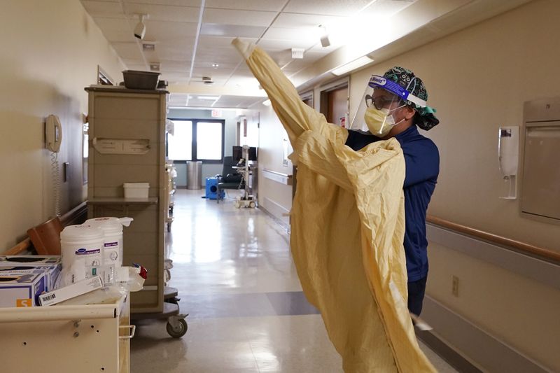 Registered Nurse Monica Quintana dons protective gear before entering a room at the William Beaumont hospital on April 21, 2021 in Royal Oak, Mich. (Carlos Osorio/AP)